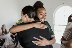 two friends embracing in their alcohol rehab program