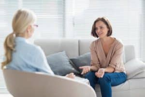 a woman talking to her doctor about an outpatient rehab center