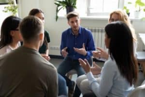 a group of people discussing in an alumni program