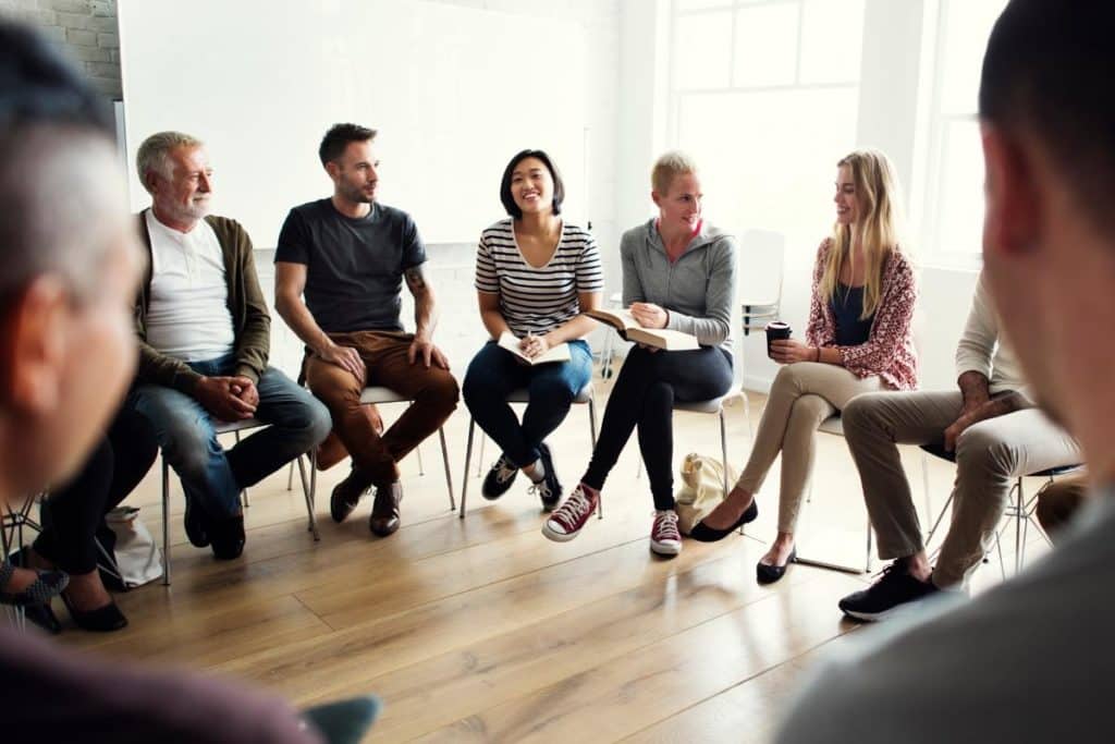 a group of people sit and talk one of many php benefits