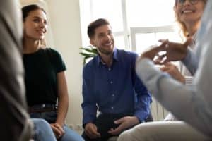 people sit in a group possibly discussing the differences between iop vs inpatient programs