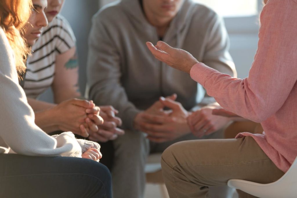 Group in therapy discuss the benefits of meth addiction treatment