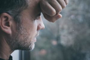 a person leans against a window, worried about cocaine and mental health