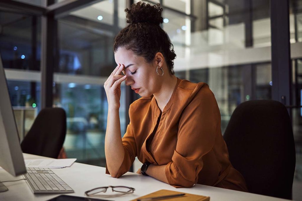 a person sitting at a desk rubbing the bridge of their nose wonders about marijuana withdrawal symptoms