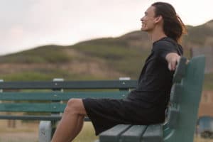 a person sits on a bunch on a mountain as they learn strategies for maintaining sobriety