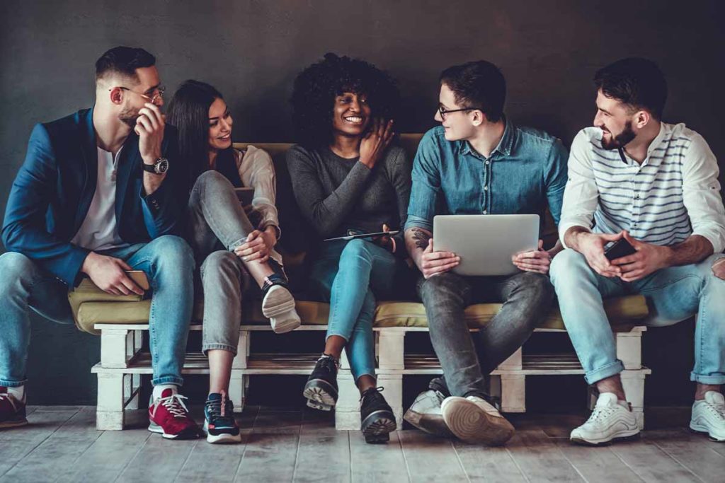 a group of people sits on a bench and goes through the stages of group therapy