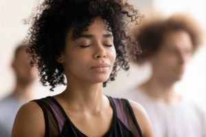 a person meditation in a yoga class tries managing anxiety