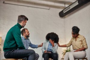 a group of people sit in a chair and support their loved one in cocaine addiction recovery