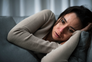 a person lays on a couch showing the physical signs of depression