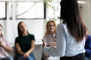 a therapist addresses a group in a PTSD treatment program