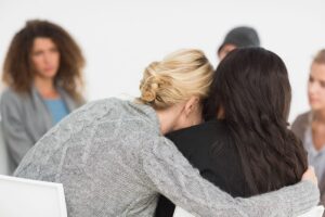 Patients in outpatient hug as they discover what a partial hospitalization program is