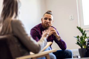 Person listens intently as woman explains the benefits of dialectical behavior therapy