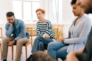 People sit and listen to person discussing their mission to find an alcohol rehab program in Omaha, NE